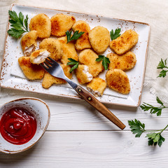 Chicken nuggets with ketchup.