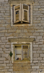 Obraz premium Windows in an old historic building in the small town of Skradin on the coast of the Sibenik-Knin County of Croatia 