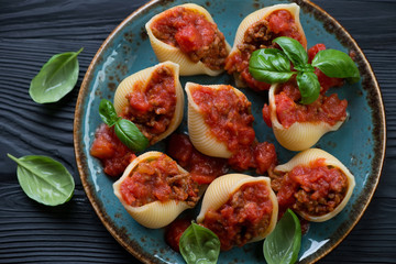Conchiglioni stuffed with mincemeat and baked in tomato sauce