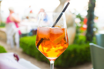 Close up of a glass of spritz cocktail, made of sparkling wine, bitter orange Italian aperitif, ice and orange slices.