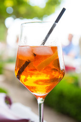 Close up of a glass of spritz cocktail, made of sparkling wine, bitter orange Italian aperitif, ice and orange slices.