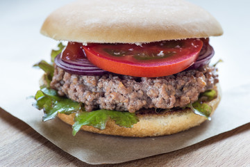 Delicious hamburger served on wooden planks