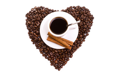 white cup of coffee on  beans as a heart