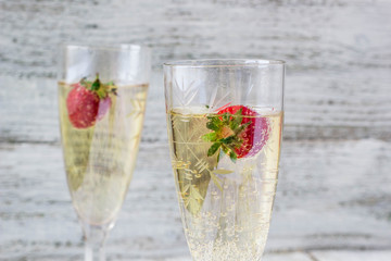 two champagne glasses and strawberries