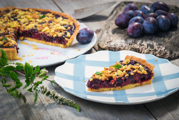 Homemade organic plum pie on wooden background