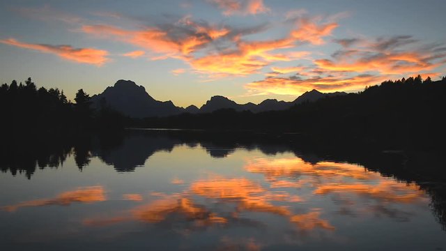 Fast motion view of bright colorful sunset reflected in the Snake River in Grand Teton National Park in Wyoming