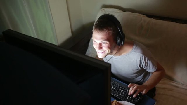 man playing video games on your computer. late at night on the computer gamer