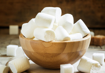 Large marshmallows in a wooden bowl, selective focus