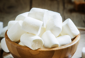 Large marshmallows in a wooden bowl, selective focus