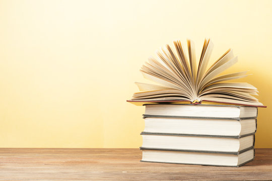 Open book, hardback books on wooden table. Education background. Back to school. Copy space for text.
