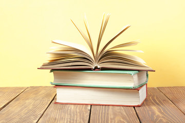 Open book, hardback books on wooden table. Education background. Back to school. Copy space for text.