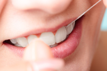 Woman smiling with dental floss.