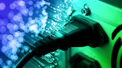 Connect and pull out electric cable into PC with Fiber optics background, shot in HD