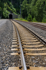 Obraz premium Two sets of train tracks curving into a tunnel 