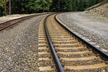 Obraz premium Two sets of train tracks curving around a hill 