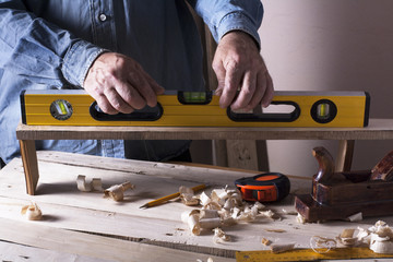 Carpenter working with plane on wooden background at Building Site. Joiner workplace