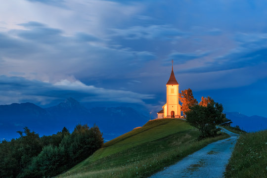 St. Primoz church near Jamnik at dawn with alps in background, Slovenia 