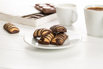 Cup of coffee and milk with cookies on a white wooden table