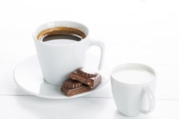 Coffee and chocolate on a white wooden table.