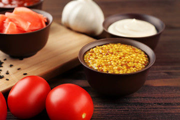 Fresh condiments and sauces on wooden background