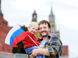 Family with russian flag with Moscow Kremlin on background