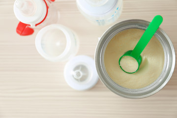 Feeding bottles and baby milk formula on wooden background