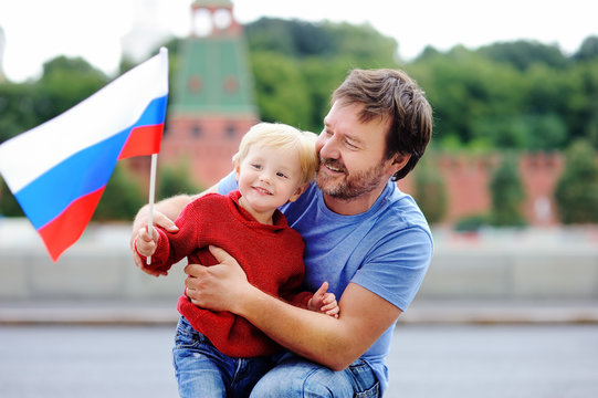 Family With Russian Flag With Moscow Kremlin On Background