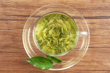 Glass cup of green tea on wooden table