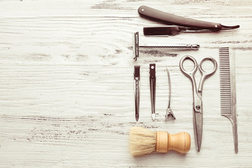 Vintage tools of barber shop on light wooden background