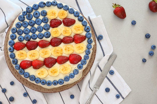 Patriotic American flag cake with berries and bananas on table