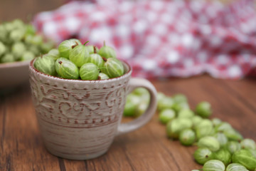 Gooseberries with cup on table