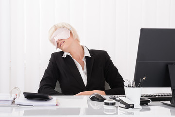 Businesswoman Wearing Eye Mask And Sleeping