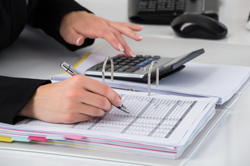 Businesswoman Hand Calculating Business Report