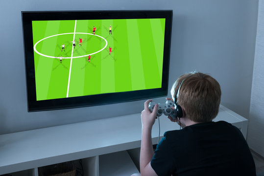 Boy Playing Football Videogame On Television