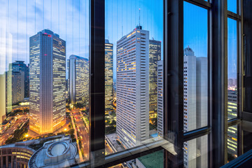 Fototapeta na wymiar modern office buildings in tokyo through window