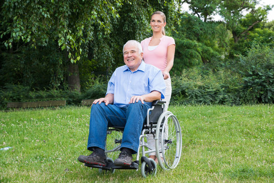 Woman With Her Disabled Father On Wheelchair
