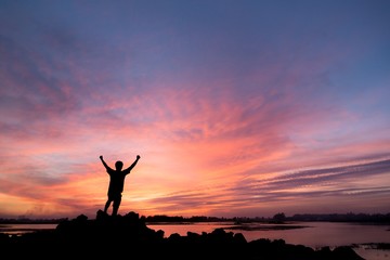 silhouette man Happy celebrating winning success at sunset