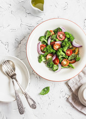 Fresh salad with broccoli and tomatoes on a light background. Healthy vegetarian food