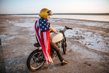 Obraz premium Man in golden in american cape sitting on his motocycle