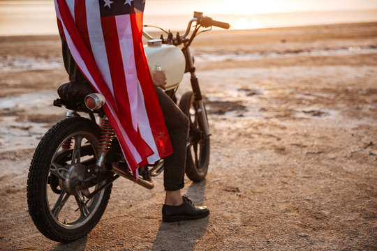 Cropped image of a man wearing american cape on motocycle