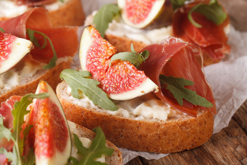 bruschetta with figs, prosciutto, arugula and cream cheese macro. Horizontal
