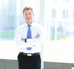 Fototapeta premium Portrait of happy smiling businessman in a modern office