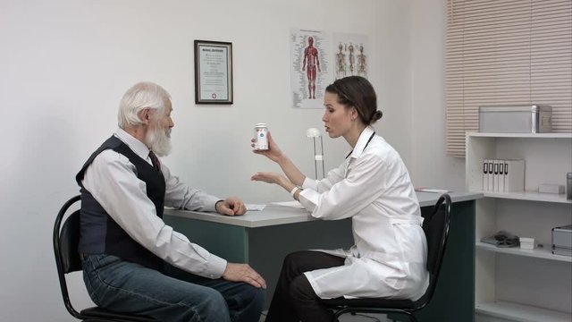 Female doctor advices senior patient to take new pills.