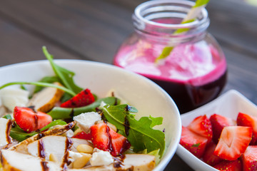 Strawberries salad with pine nuts, arugula and chicken. Beet  fresh juice. Healthy & fitness food.