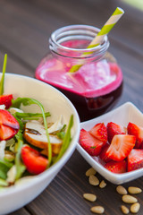 Strawberries salad with pine nuts, arugula and chicken. Beet  fresh juice. Healthy & fitness food.