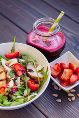 Strawberries salad with pine nuts, arugula and chicken. Beet  fresh juice. Healthy & fitness food.