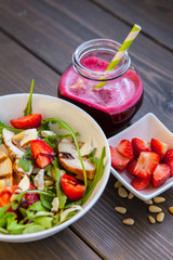 Strawberries salad with pine nuts, arugula and chicken. Beet  fresh juice. Healthy & fitness food.