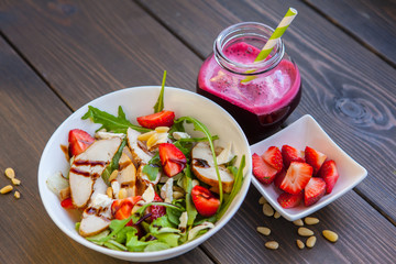 Strawberries salad with pine nuts, arugula and chicken. Beet  fresh juice. Healthy & fitness food.