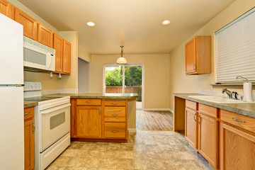 Classic American kitchen room with wooden cabinets and tile floor.