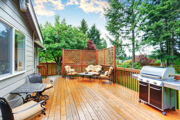Spacious wooden deck with patio area and attached pergola.